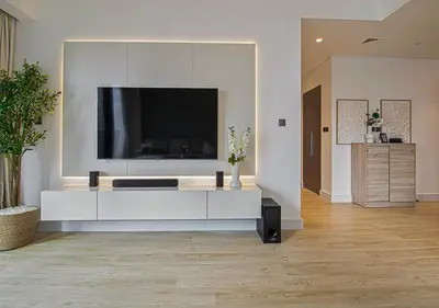 a living room with a large tv on a white wall at Brand new 2BR in Downtown 5 min walk to Burj Khalifa in Dubai