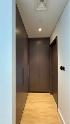 an empty corridor with wooden doors in a building at Brand new 2BR in Downtown 5 min walk to Burj Khalifa in Dubai