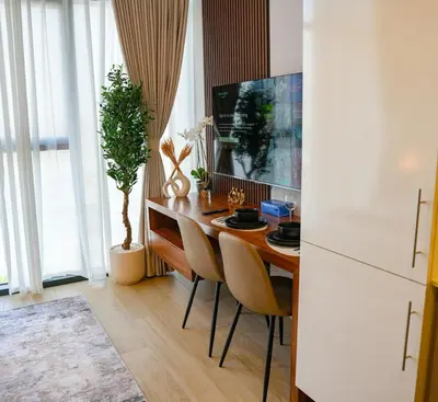 a kitchen with a table with chairs and a tv at New Studio in Meydan With Pool & Gym in Dubai