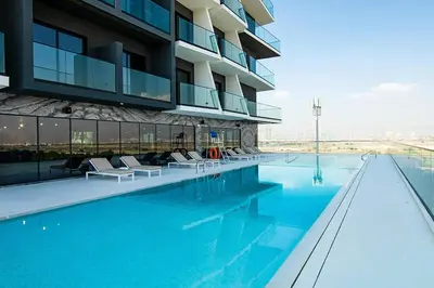 a swimming pool with chairs and a building at PVH - Binghatti Heights - Urban Luxury 3BR in Dubai