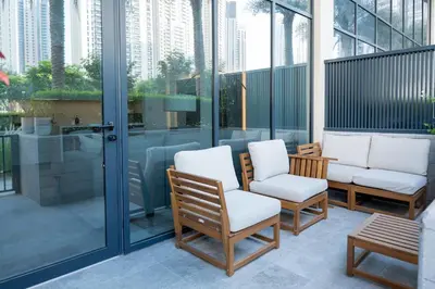 a patio with chairs and a shower on a building at Homely Creek Harbour Apartment - Direct Park Access in Dubai