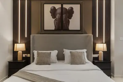 a bedroom with a large white bed with two lamps at Gogoto4 - 2BR High Floor Burj View Infinity Pool PS5 NYE Fireworks View in Dubai