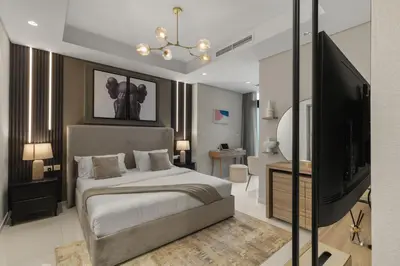 a bedroom with a bed and a flat screen tv at Gogoto4 - 2BR High Floor Burj View Infinity Pool PS5 NYE Fireworks View in Dubai