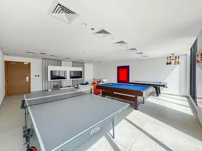 a large room with two ping pong tables in it at Chic Studio APT with Pool & Gym - Near Metro Station in Dubai