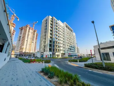 an empty street with two tall buildings in a city at Stylish Apartments in a Vibrant Community in Dubai