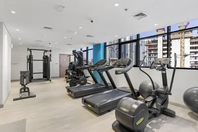 a gym with treadmills and cardio equipment in a building at Stylish Apartments in a Vibrant Community in Dubai