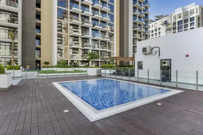a swimming pool in the middle of a courtyard with buildings at Stylish Apartments in a Vibrant Community in Dubai