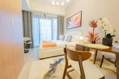 a living room with a bed and a dining room at Modern Studio Retreat in Dubai in Dubai
