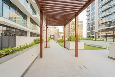 a walkway in a building with awnings and plants at Modern Studio Retreat in Dubai in Dubai