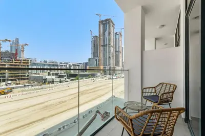 a balcony with two chairs and a view of a beach at Cozy Downtown Studio Dubai Retreat in Dubai