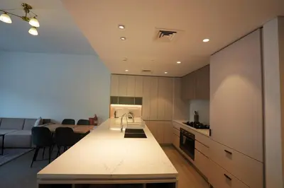 a kitchen and living room with a couch and a table at Spacious 3BR in Sobha Hartland near Downtown in Dubai