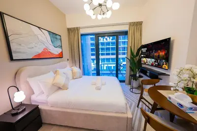 a bedroom with a bed and a desk and a television at Stunning Studio with Swimming Pool View in Dubai