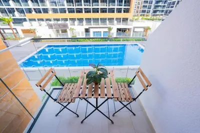 two chairs and a plant next to a swimming pool at Stunning Studio with Swimming Pool View in Dubai