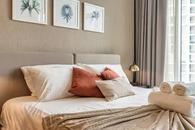 a bedroom with a bed with white sheets and pillows at Canal View & High Floor & Valet in Dubai