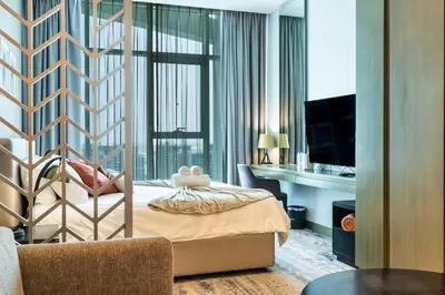 a bedroom with a bed and a desk and a computer at Canal View & High Floor & Valet in Dubai