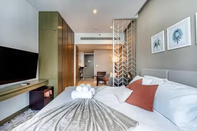 a bedroom with a large white bed with a flat screen tv at Canal View & High Floor & Valet in Dubai