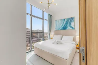 a bedroom with a white bed and a large window at 1-Bedroom Oasis with Views in Dubai