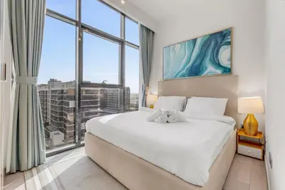 a bedroom with a large bed with a large window at 1-Bedroom Oasis with Views in Dubai