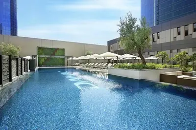 a large swimming pool in a building with umbrellas at Luxury Studio close to Dubai Mall and Burj Khalifa in Dubai