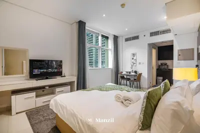 a bedroom with a bed with a tv on a counter at Luxury Studio close to Dubai Mall and Burj Khalifa in Dubai