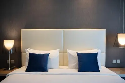 a bed with blue pillows in a hotel room at Stylish 1BR in Damac by Paramount Business Bay in Dubai