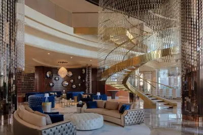 a lobby with a spiral staircase and blue furniture at Stylish 1BR in Damac by Paramount Business Bay in Dubai