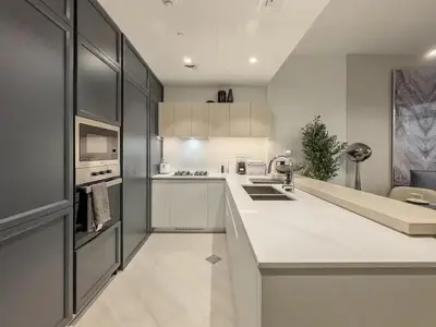 a kitchen with white cabinets and a white counter top at Amazing Brand New 1BR in Dubai