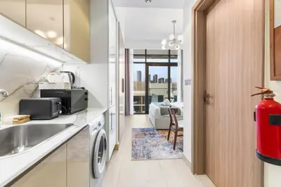 a kitchen with a sink and a washing machine at Stylish City Studio with Burj Khalifa View in Dubai