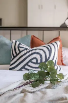a plant sitting on top of a bed with pillows at GuestReady Holiday Homes - Industrial Chic in Dubai