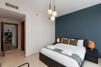 a bedroom with a large bed with a blue wall at Blakely Tower, Park Island, Dubai Marina - Mint Stay in Dubai