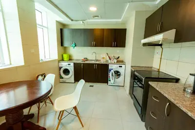 a kitchen with a table and a table and chairs at Al Barsha Hostel for Girls in Dubai