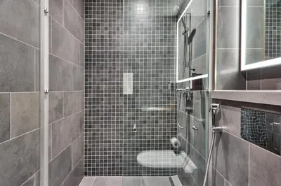 a bathroom with a shower with black tiles at STAY BY LATINEM Luxury 1BR Holiday Home CC 0813 Near Downtown in Dubai