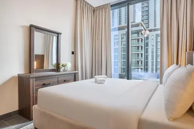 a bedroom with a large white bed and a large window at STAY BY LATINEM Luxury 1BR Holiday Home CC 0813 Near Downtown in Dubai