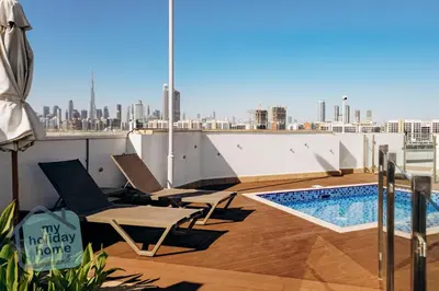 a balcony with chairs and a swimming pool on a building at Exclusive 2BR With City View Pool & Gym Access in Dubai