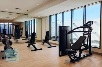 a gym with treadmills and ellipticals in a building at Exclusive 2BR With City View Pool & Gym Access in Dubai