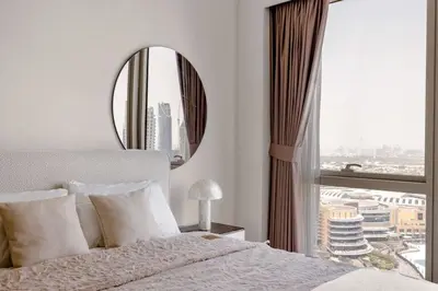 a bedroom with a large window and a mirror at Burj Khalifa View Apartment in Dubai