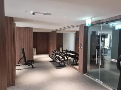 a gym with a row of treadmills and machines at FAM Living -Bright & Spacious Home in Sobha Hartland in Dubai