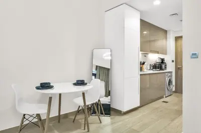 a kitchen and dining room with a white table and chairs at Exclusive Downtown Dubai Studio in Dubai