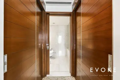 a hallway with wood paneled walls and a bathroom at Kempinski Luxe Studio Burj Khalifa View by Evoke in Dubai