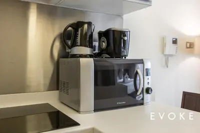 a microwave sitting on top of a kitchen counter at Kempinski Luxe Studio Burj Khalifa View by Evoke in Dubai
