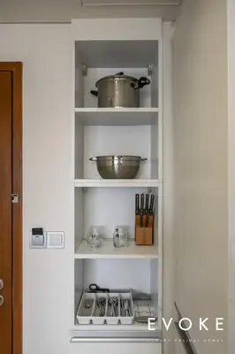 a kitchen shelf with pots and pans on it at Kempinski Luxe Studio Burj Khalifa View by Evoke in Dubai