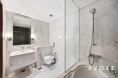 a bathroom with a toilet and a sink and a shower at Kempinski Luxe Studio Burj Khalifa View by Evoke in Dubai