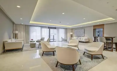 a large lobby with chairs and tables in a building at Iconic Burj Khalifa, Fountain Views, Luxury 2BR in Sabkhah
