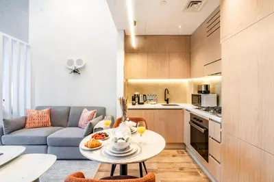 a small living room with a table and a couch at Luxury Apartment In JVC With Padel Gym Pool Cinema BBQ in Dubai