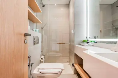a bathroom with a toilet and a sink at Luxury Apartment In JVC With Padel Gym Pool Cinema BBQ in Dubai
