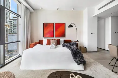 a bedroom with a large white bed and a large window at Stylish 1BR with Work Desk, Pool and Gym in Dubai