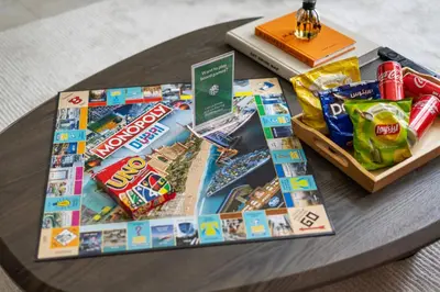 a table with a board game and snacks on it at Stylish 1BR with Work Desk, Pool and Gym in Dubai