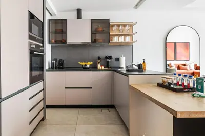 a kitchen with white cabinets and a counter top at Stylish 1BR with Work Desk, Pool and Gym in Dubai