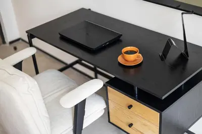 a black table with an orange cup on a plate at Stylish 1BR with Work Desk, Pool and Gym in Dubai