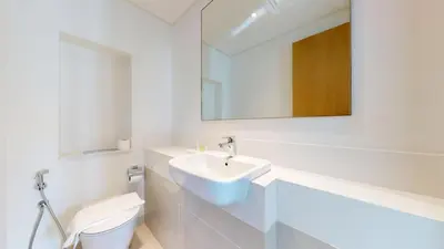 a white bathroom with a sink and a toilet at Harbour Views - Chic Three Bed with Creek Views in Dubai
